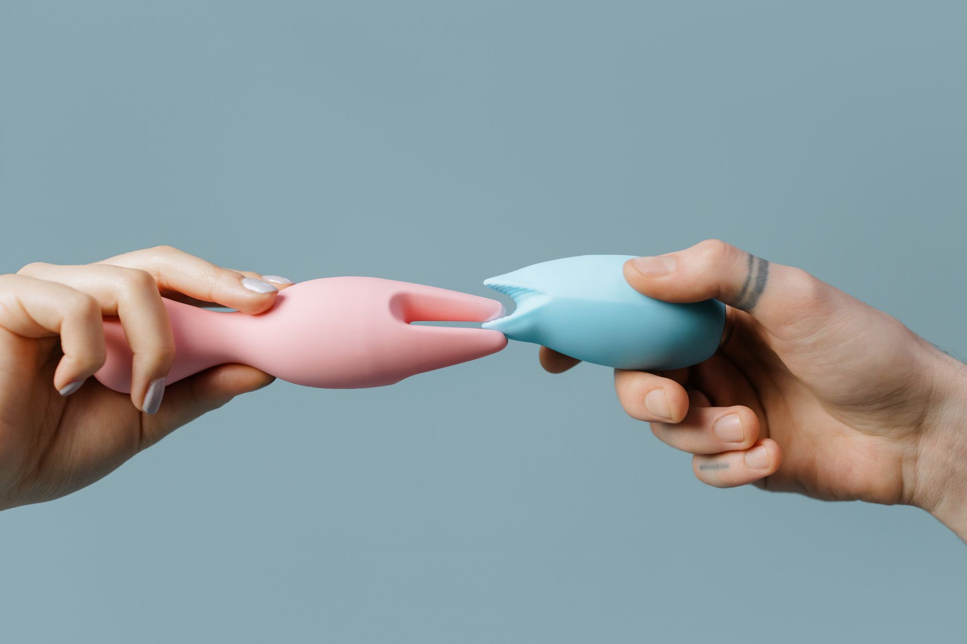 Hands holding a vibrator together during intimate partnered moment